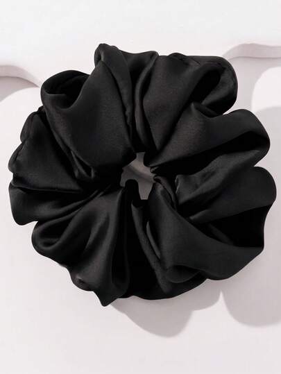 A single black satin hair scrunchie photographed on a clean white background.